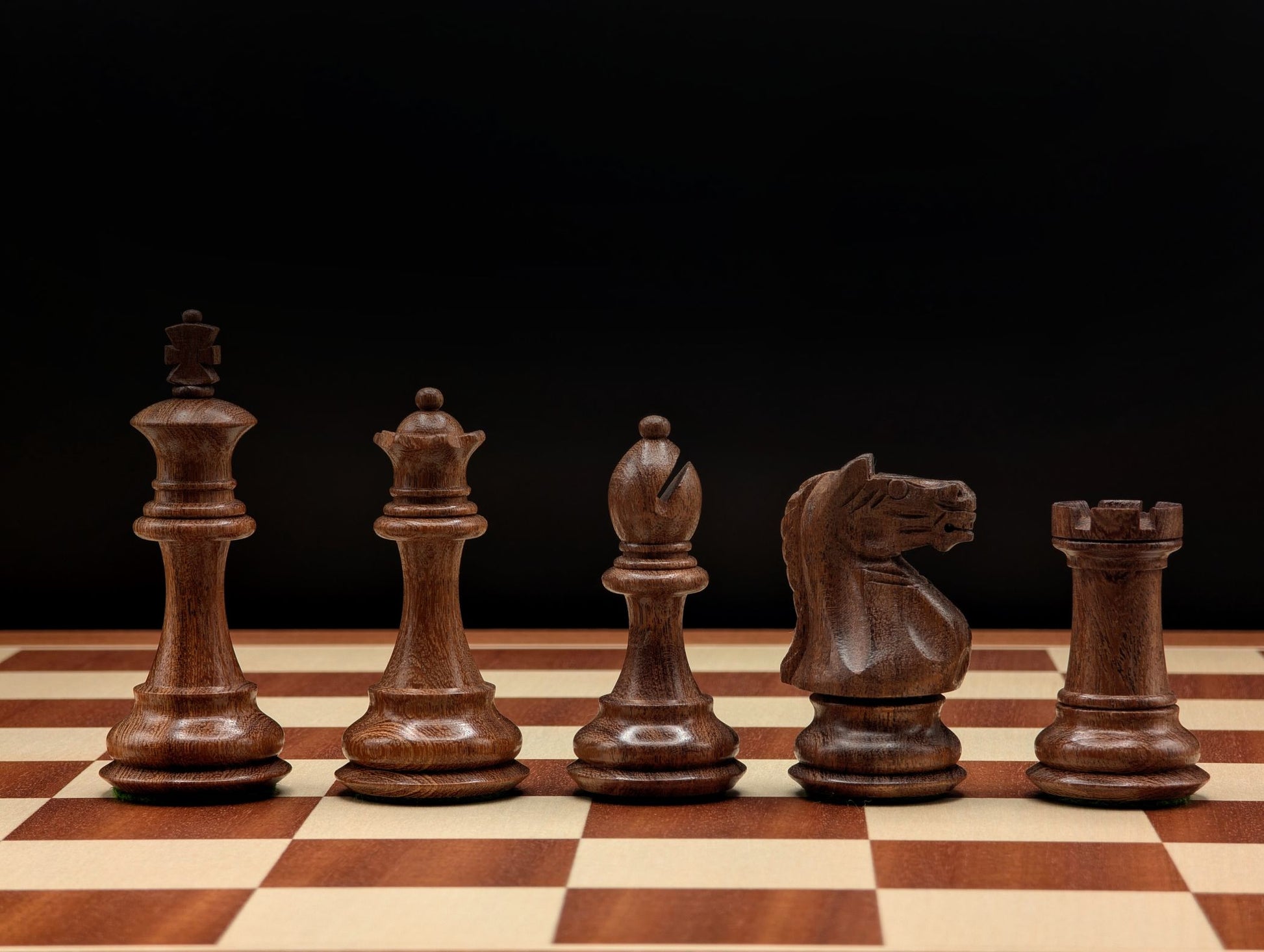 Pièces d'échecs lestées avec double dame sur un plateau de luxe, offrant une expérience de jeu tactile unique.