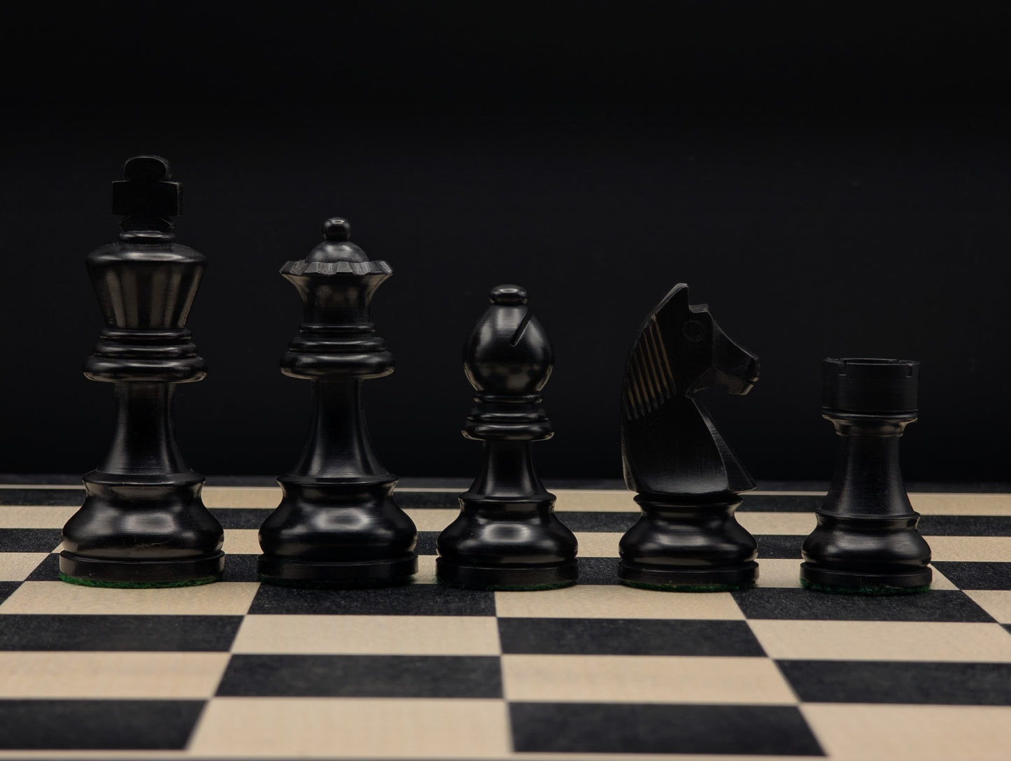 Pièces d'échecs en buis ébonisé noir profond, style épuré avec double dame incluse.