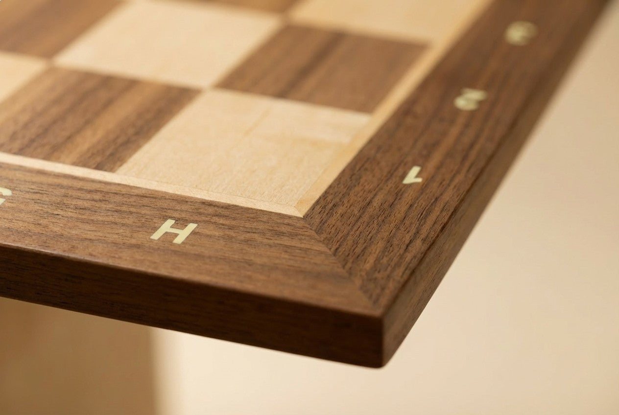 Détail des finitions d'un échiquier artisanal en noyer et érable, design sobre et élégant.
